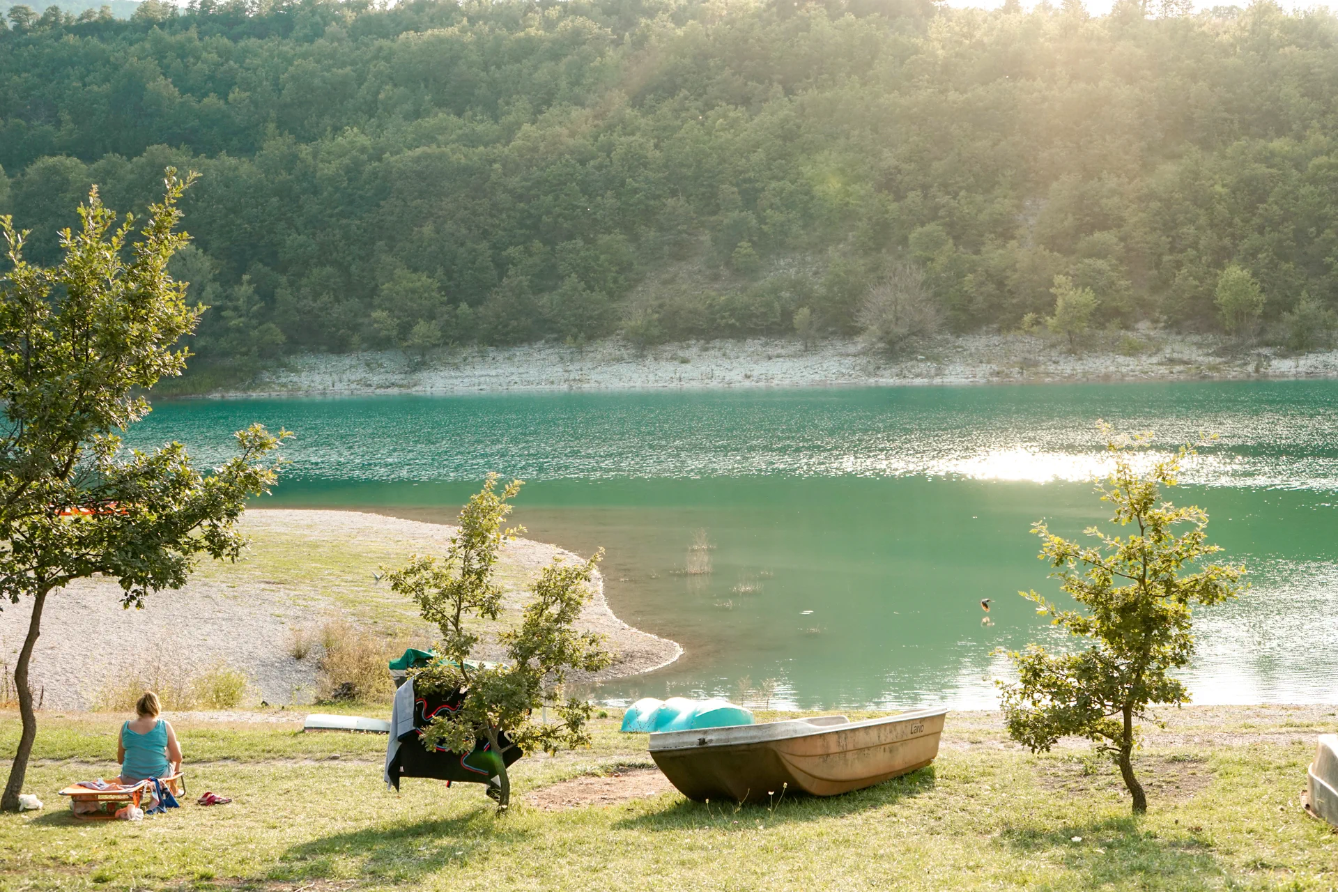 Le acque turchesi del Lago di Fiastra con una barca sulla riva, nel Parco dei Monti Sibillini
